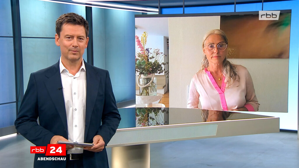Moderator der rbb24 Abendschau im Studio, im Hintergrund ein Interviewbild von Dr. med. Silke Schwarz zum Thema Bildschirmzeit bei Kleinkindern